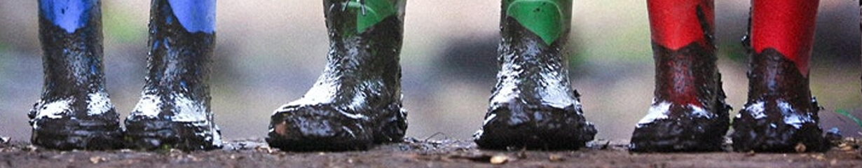 three pairs of colourful and very muddy wellies