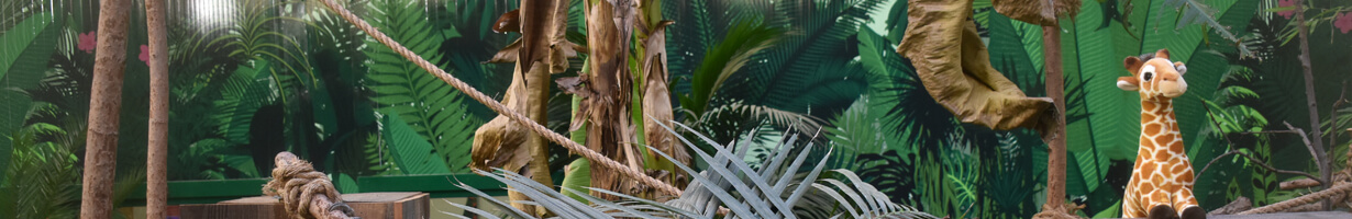 A toy giraffe hiding in a rainforest scene