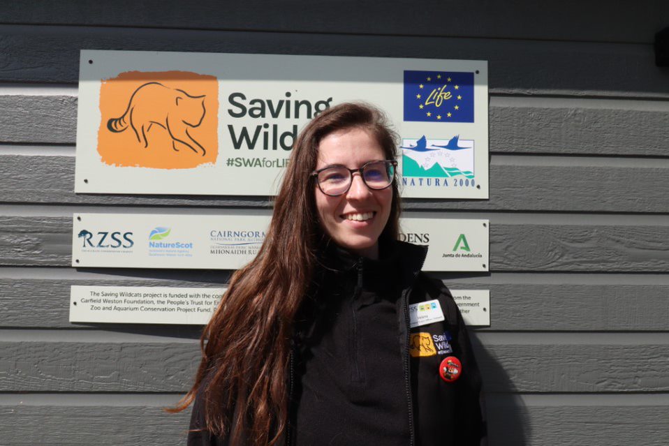 A photograph of Helena Parsons, Saving Wildcats team member, in front of the Saving Wildcats headquarters at RZSS Highland Wildlife Park