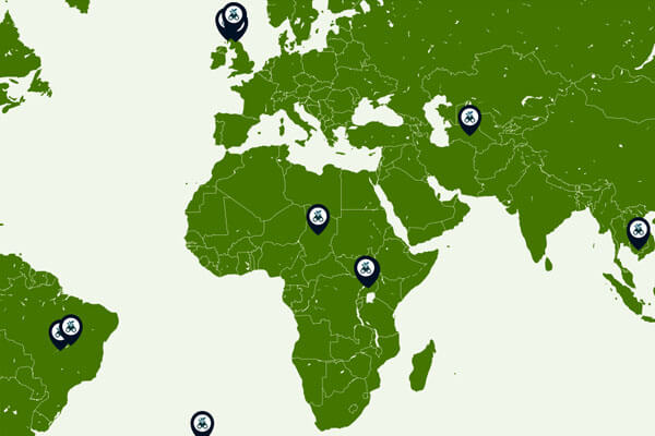 A map of the world, with the countries in green, with navy blue icons highlighting different conservation projects
