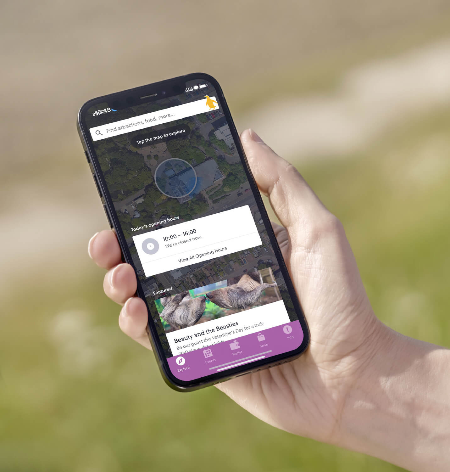 a hand holding a mobile phone showing the new edinburgh zoo app